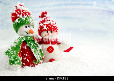 two smiling snowmen friends in the snow - no name toy Stock Photo