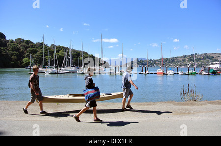 man and teenagers carry kayak at ayala cove on Angel island state park Stock Photo