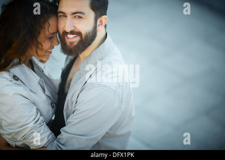 Image of happy man looking at camera while embracing his sweetheart Stock Photo