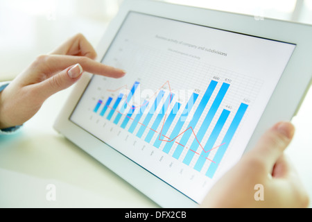 Female worker analyzing financial results with the help of a digital pad Stock Photo