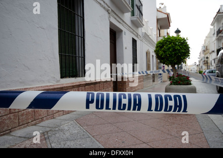 Police crime scene tape across pavement in street in Nerja, Spain. Stock Photo