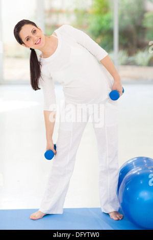 beautiful young pregnant woman working out with dumbbells Stock Photo