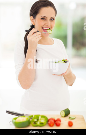 cute pregnant woman eating salad at home Stock Photo