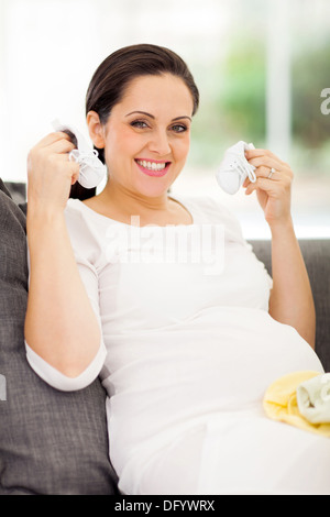 beautiful pregnant woman holding baby shoes Stock Photo
