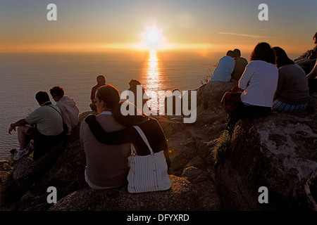 Tourists and pilgrims in Cape Finisterre enjoying a sunset. Finisterre.CoruÃ±a province.Spain. Camino de Santiago Stock Photo