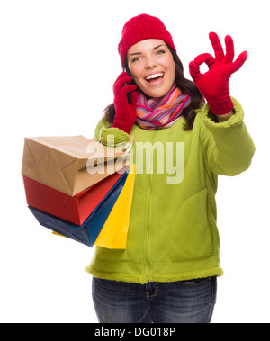 Mixed Race Woman Holding Shopping Bags Talking On Her Cell Phone Giving Ok Gesture Isolated on White Background. Stock Photo