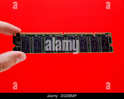 Hand holding computer ram isolated on red background Stock Photo