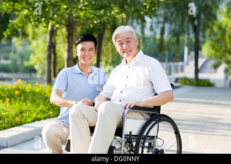 Wheelchair bound man with nursing assistant Stock Photo