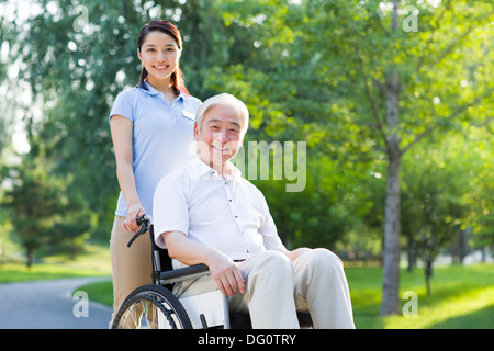 Wheelchair bound man with nursing assistant Stock Photo