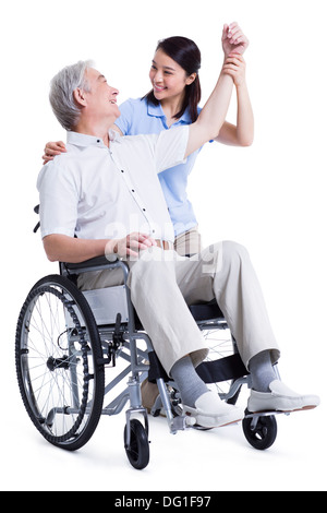 Female nursing worker helping senior man doing exercise Stock Photo