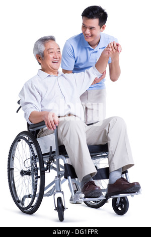 Male nursing worker helping senior man doing exercise Stock Photo