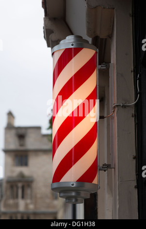 a barber's red and white striped pole outside a shop in Cambridge UK Stock Photo