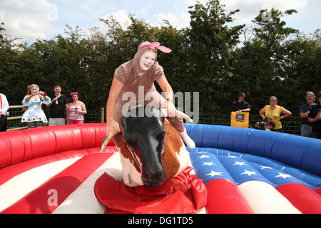 Riding a bucking bronco in fancy dress Stock Photo