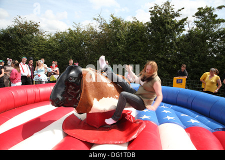 Riding a bucking bronco in fancy dress Stock Photo