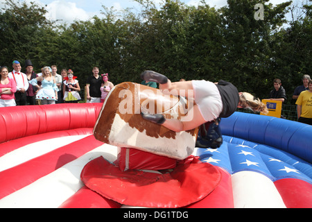 Riding a bucking bronco in fancy dress Stock Photo