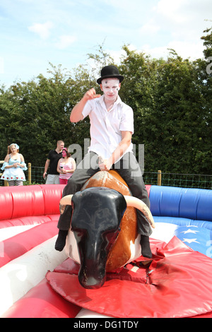 Riding a bucking bronco in fancy dress Stock Photo