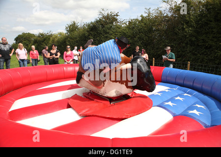 Riding a bucking bronco in fancy dress Stock Photo