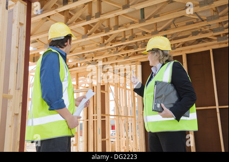 Civil engineer and worker discussing issues at the construction site .Focus on the rear Stock Photo
