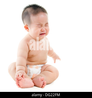 Full body upset Asian baby boy crying, sitting isolated on white background Stock Photo
