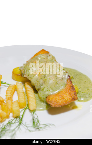 roasted salmon served with green sauce and french fries on white plate Stock Photo