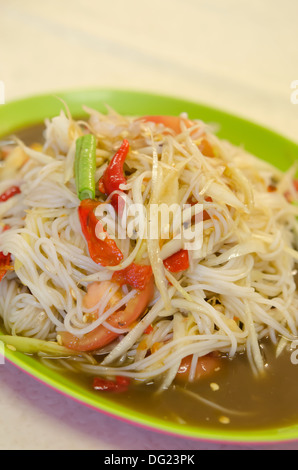 Rice noodle and vegetable salad on a plate on a wooden table with ...