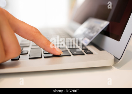 Female laptop enter button finger table desk indoor Stock Photo