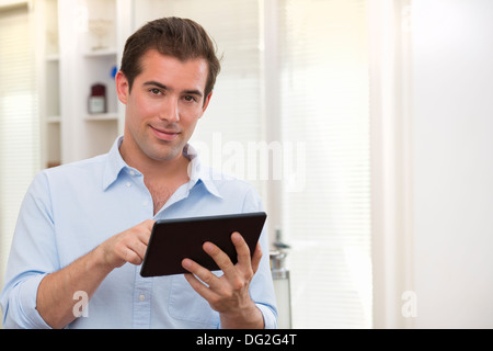 Male working on digital tablet at home Stock Photo