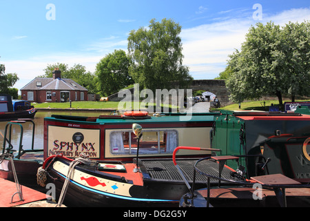 Narrowboats moored on the Shropshire Union Canal at Norbury Junction, the redundant Newport branch visible under the bridge Stock Photo