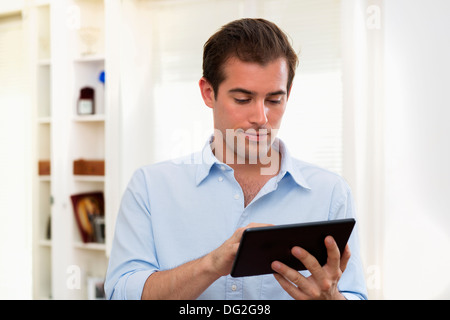 Male working on digital tablet at home Stock Photo