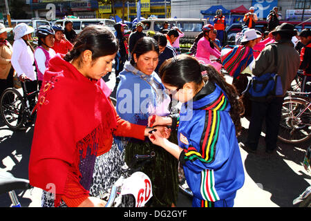 El Alto, Bolivia. 12th Oct, 2013.  A competitor has her wrist stamped before the start to show she is registered to take part in a Cholitas Bicycle Race for indigenous Aymara women. The race is held at an altitude of just over 4,000m along main roads in the city of El Alto (above the capital, La Paz) for Bolivian Womens Day, which was yesterday Friday October 11th. Credit:  James Brunker / Alamy Live News Stock Photo