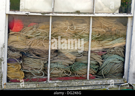 Lobster trap lines in shed window Stonington Maine Coast New England USA Stock Photo
