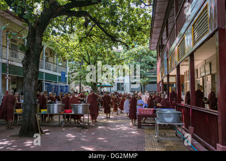 Monk's lining up in the courtyard to receive their midday meal, Mahagandayon Monastery, Amarapura, Myanmar Stock Photo