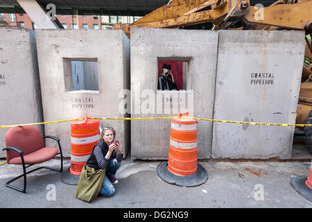 New York, USA. 12th Oct, 2013. Street art enthusiasts flock to the East Village neighborhood of  New York on Saturday, October 12, 2013 to see the twelfth installment of Banksy's graffiti art, 'Concrete confessional'. The elusive street artist is creating works around the city each day during the month of October accompanied by a satirical recorded message which you can hear by calling the number 1-800-656-4271 followed by  # and the number of artwork.  Credit:  Richard Levine/Alamy Live News Stock Photo