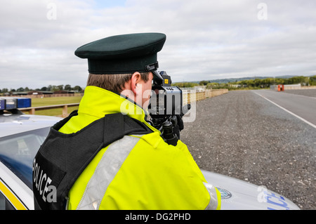 Police officer uses a Laser Technology Inc UltraLyte laser speed detector gun Stock Photo
