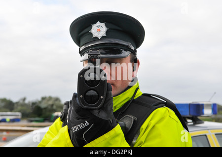 Police officer uses a Laser Technology Inc UltraLyte laser speed detector gun. Stock Photo