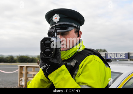 Police officer uses a Laser Technology Inc UltraLyte laser speed detector gun (front on) Stock Photo