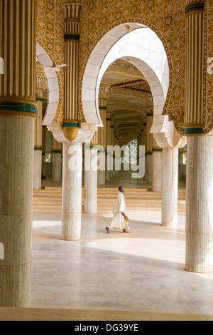Senegal, Touba. Worshipper Carrying Shoes Walking through Prayer Halls for Overflow Crowds at the Grand Mosque. Stock Photo
