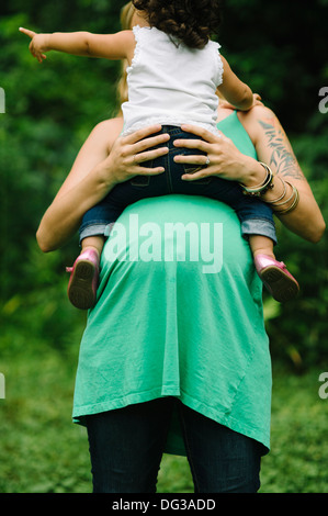 Pregnant Woman Holding Young Child on Belly Stock Photo