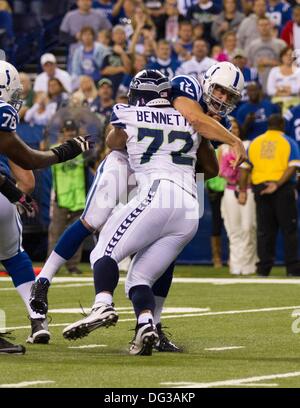 Michael Bennett (72) of the Seattle Seahawks loses his helmet as he tackles  Eddie Lacy (27) of the Green Bay Packers in the NFC Championship game at  CenturyLink Field in Seattle, Washington