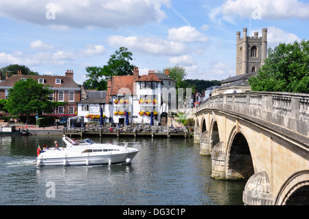 Oxon - Henley on Thames - view across the river to Angel inn - boat approaching the old town bridge - summer sunlight - blue sky Stock Photo