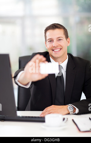 cheerful young businessman presenting white business card Stock Photo