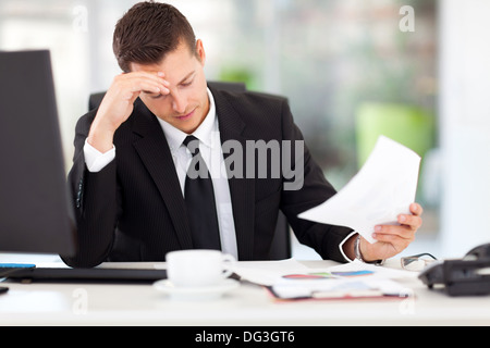 stressed businessman reading documents in office Stock Photo