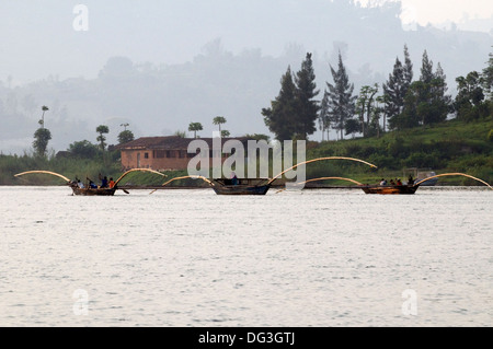 Flotilla of fishing boats working together with extended poles trawling the nets on Lake Kivu in Rwanda Central Africa Stock Photo