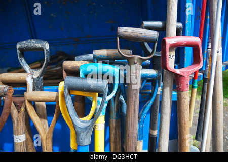 A group of used, secondhand, garden forks, tools, spades on sale on a stall at an outdoor market. Stock Photo