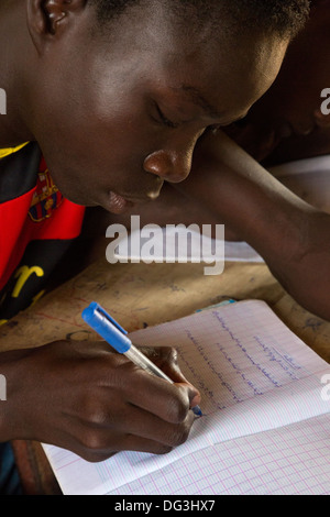 Senegal, Touba. Boy at Al-Azhar Madrasa, a School for Islamic Studies, writing in Arabic in his notebook. Stock Photo