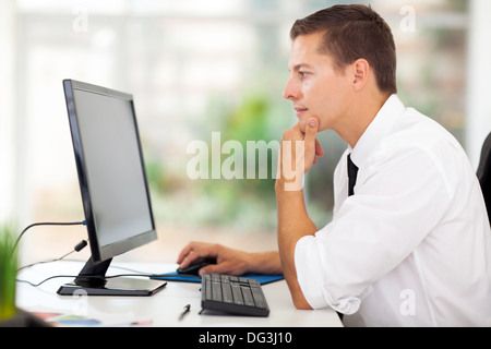 thoughtful young businessman looking at computer screen Stock Photo