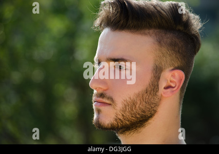 Portrait of handsome young man outdoors in nature, looking to a side Stock Photo