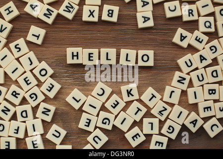Plastic letters from a childrens' spelling game on a wooden table spell 'hello' Stock Photo