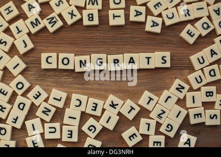 Plastic letters from a childrens' spelling game on a wooden table spell 'congrats' Stock Photo