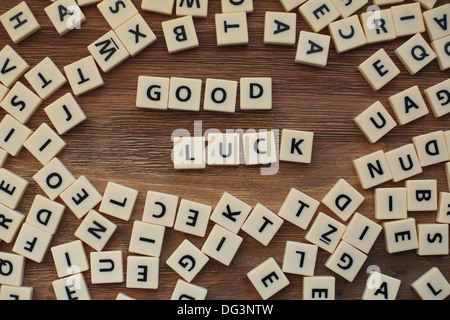 Plastic letters from a childrens' spelling game on a wooden table spell 'Good Luck' Stock Photo